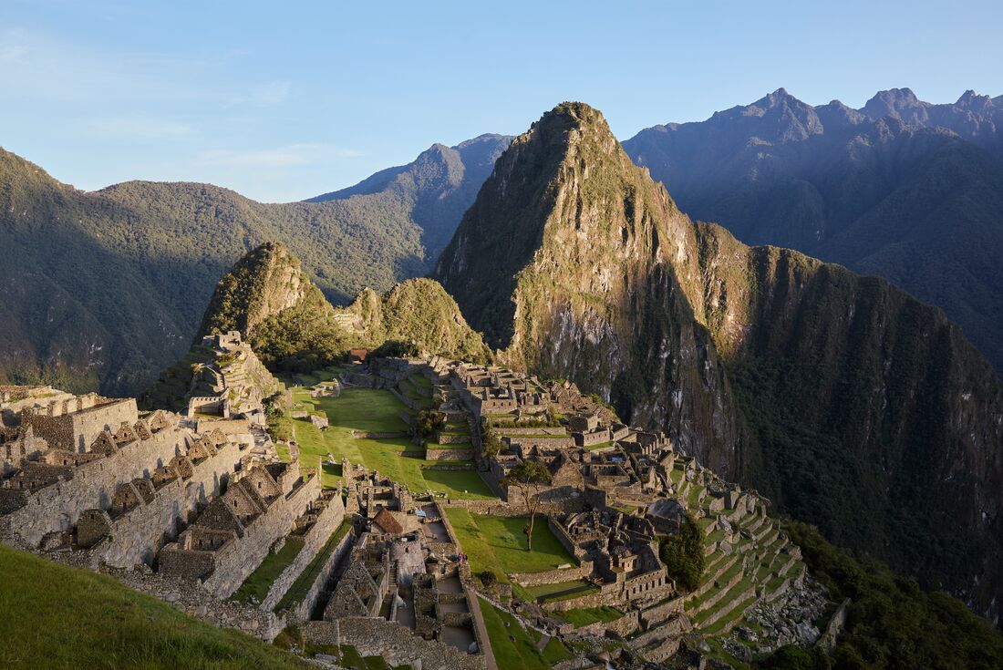 Sun hitting the mountains and ruins of Machu Picchu in Peru