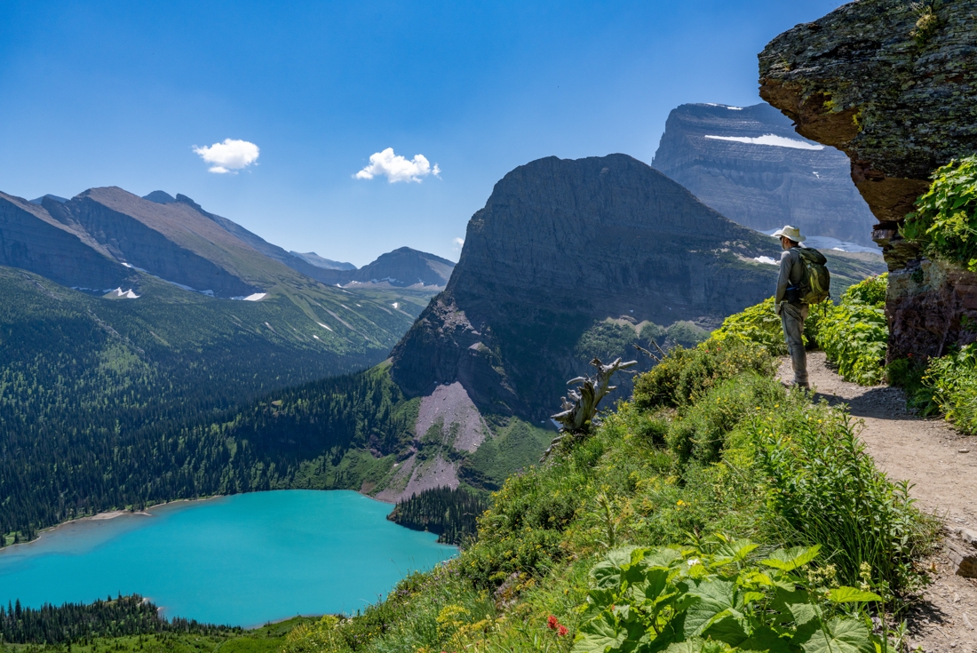 Traveller looks out in awe of Grinnell Lake and Mount Grinnell in Glacier National Park