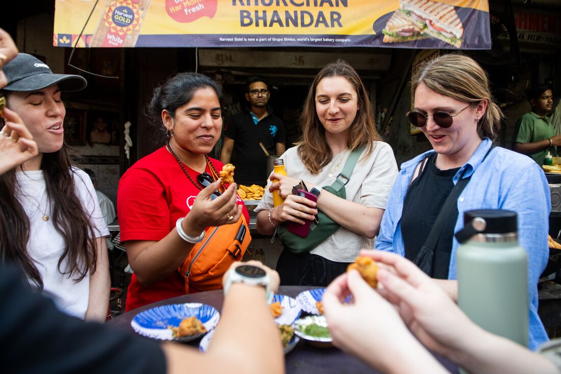 Leader and travellers sharing street food in Delhi, India