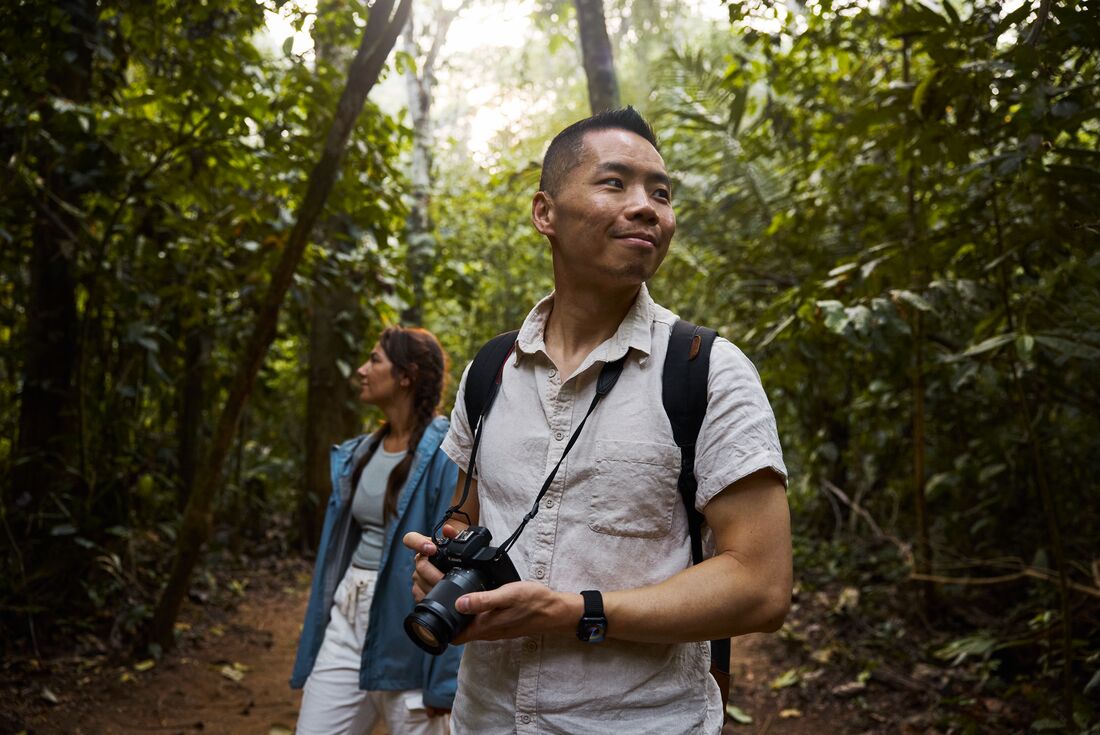 Intrepid travellers look around camera poised in the Amazon rainforest in Peru